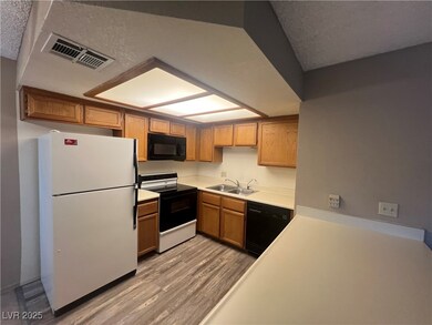 Kitchen featuring black appliances, a sink, light