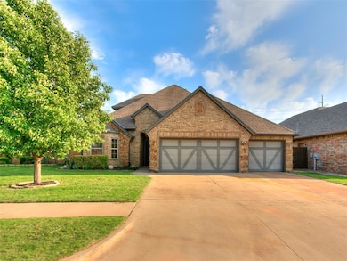 View of front facade with an attached garage, concrete driveway, brick siding, and a front yard