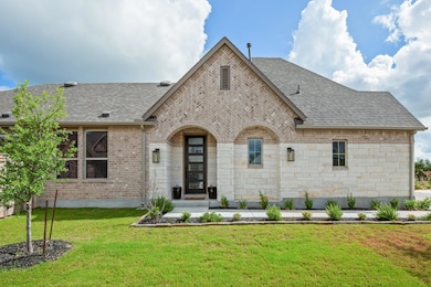 View of front facade with a front yard, roof with