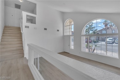 Entrance foyer with light wood-type flooring and v