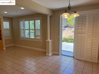 Entryway featuring decorative columns, light tile patterned floors, a chandelier, and recessed lighting