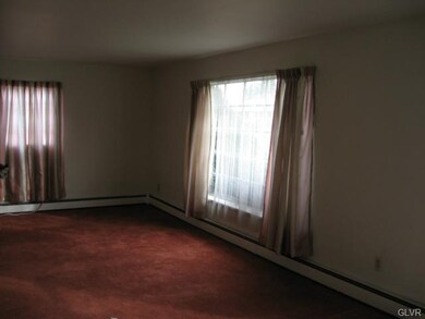 Newer carpet in living room with hardwood beneath.