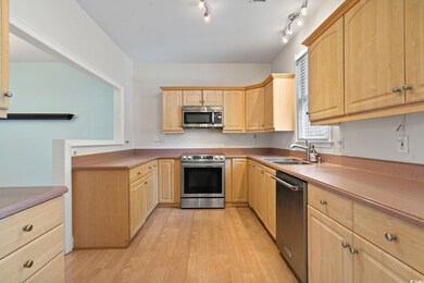 Kitchen with light brown cabinets, light hardwood 