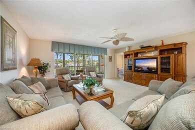 Living room featuring light carpet, a textured ceiling, and ceiling fan
