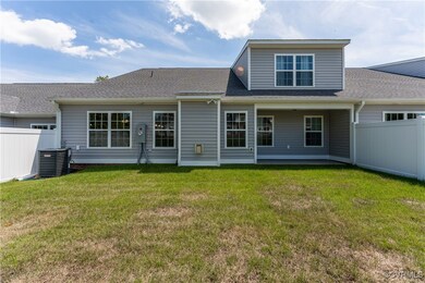 Rear view of property featuring a yard and cooling