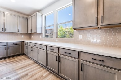 Kitchen featuring light countertops, light wood-ty