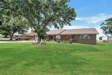 View of front of house with a front lawn, driveway, an attached garage, brick siding, and a shingled roof