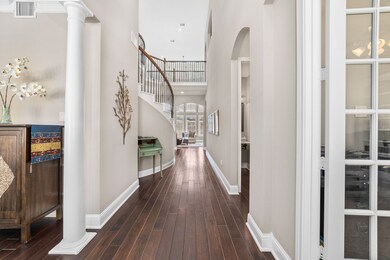 This 2-story foyer leads to the open family room with Carlisle Espresso Wood Floors.
