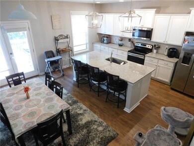 Kitchen with stainless steel appliances, healthy amount of natural light, a kitchen bar, and white cabinets