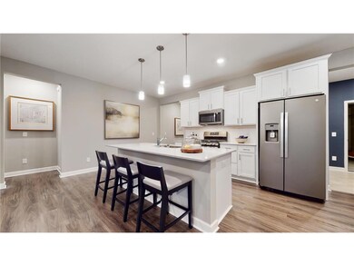 This dream kitchen features plenty of cabinet space, an oversized center island, quartz countertops, tile backsplash, walk-in pantry and the popular slate finish appliances! Photo of model home, colors and finishes will vary.