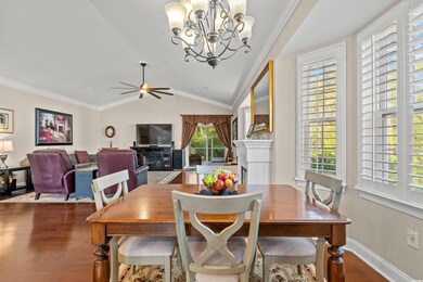 Dining room with ceiling fan with notable chandeli