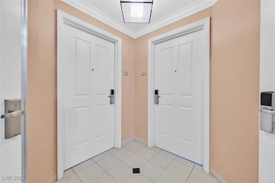 Foyer featuring light tile patterned floors, baseb