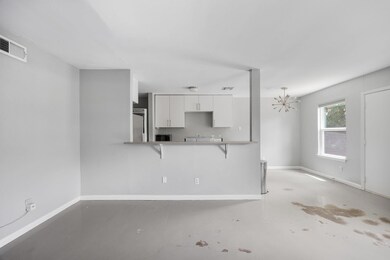 Kitchen featuring concrete flooring, white cabine
