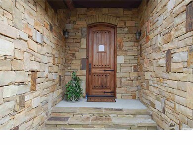 Flagstone steps lead to a covered entry with mahogany front door.