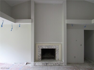 Unfurnished living room featuring a fireplace and vaulted ceiling