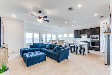 Living area with a ceiling fan, recessed lighting, and light tile patterned floors
