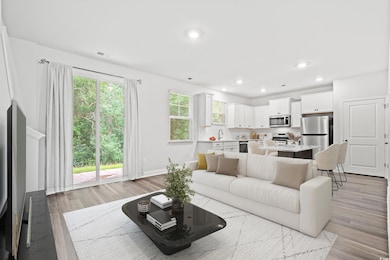 Living area with light wood-type flooring and recessed lighting