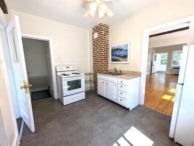 Kitchen with white cabinets, white appliances, sin