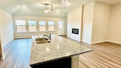 Kitchen with a sink, ceiling fan, wood finished fl