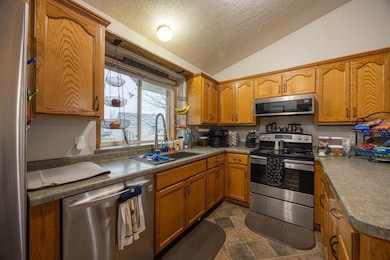 Kitchen with new stainless steel appliances and farmhouse sink.