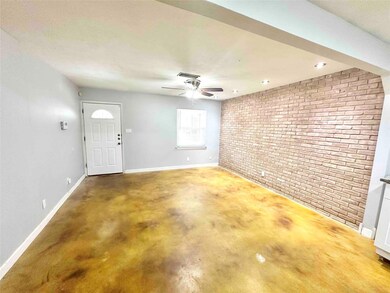 Entrance foyer featuring brick wall, baseboards, 