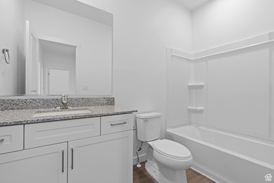 Full bathroom featuring vanity, dark wood-type flooring, and shower / washtub combination