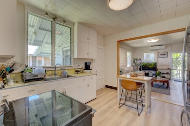 Kitchen looking toward living room.  Owners install support beam to be able to remove wall between living & kitchen when purchased in 2023.