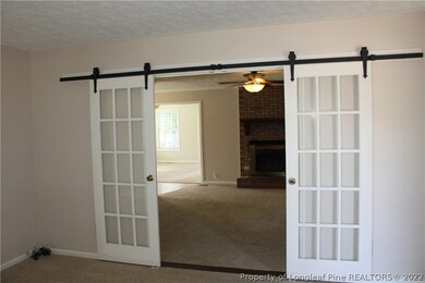 Formal living looking into family room through open barn doors