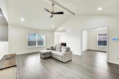 Living room featuring beam ceiling, high vaulted ceiling, LVP flooring, and ceiling fan