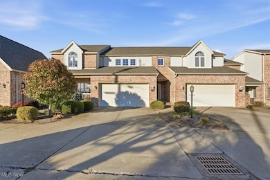 Traditional home with driveway, a garage, brick siding, and roof with shingles