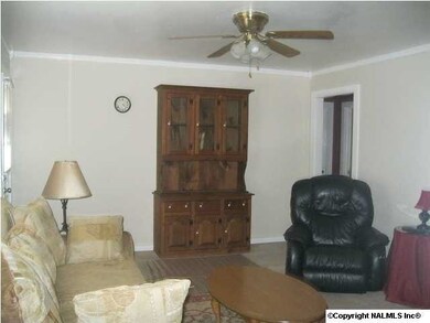 Livingroom has carpet, ceiling fan and crown molding.