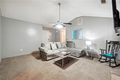 Carpeted living room with lofted ceiling and ceiling fan
