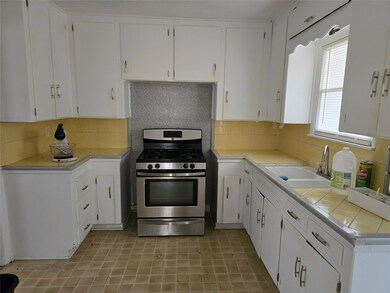 Kitchen featuring sink, tile countertops, backspla