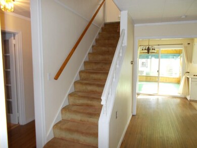 Staircase at one side of the livingroom leads to s