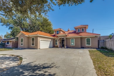 Mediterranean / spanish-style house with stucco siding, concrete driveway, a garage, a chimney, and a tile roof
