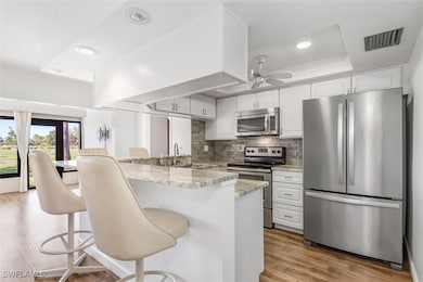 Kitchen featuring kitchen peninsula, light wood-ty