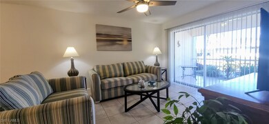 Tiled living room with ceiling fan and slider to l