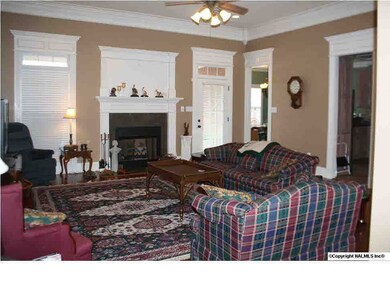 Large family room has wonderful hardwood floors, cozy fireplace and nice windows overlooking the private backyard, covered patio and pool.