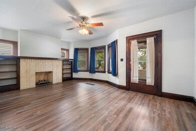 Unfurnished living room featuring ceiling fan, a fireplace, and hardwood / wood-style floors