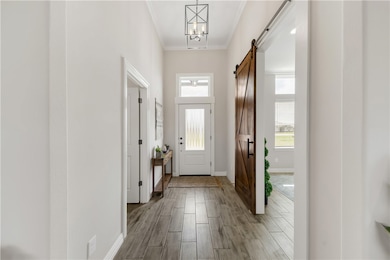 Foyer entrance featuring baseboards, a barn door,