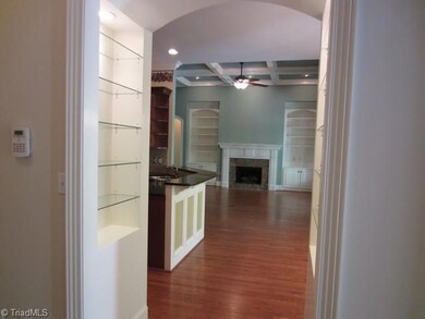 View of the Great Room and Kitchen from the back hall.  The Breakfast area is to the right in a bay of windows overlooking the screened porch.  Niches on either side of the doorway provide architectural detail and a lovely place for special displays  The arched doorway is another architectural refinement found in this home..