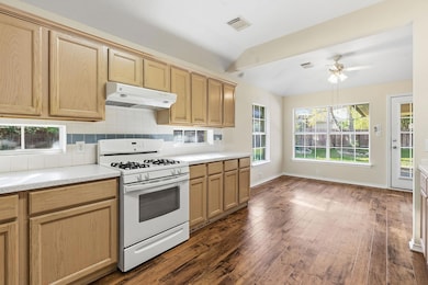 Kitchen featuring white range with gas cooktop, b