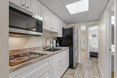 Kitchen featuring white cabinetry, stainless steel