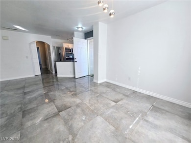Unfurnished living room with arched walkways and b