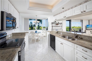Kitchen featuring stainless steel electric range, a sink, dishwasher, a chandelier, and light stone countertops