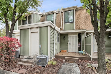 View of front facade featuring a shingled roof, mansard roof, and a wooden deck