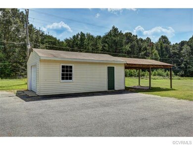 Vinyl sided garage with attached shed and paved dr