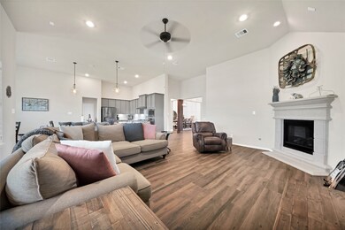 Living room with gas fireplace opens to the kitchen and breakfast area