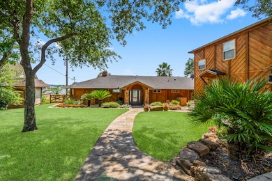 Charming home with a rustic wooden exterior, beautifully landscaped front yard, and a stone pathway leading to the entrance. Surrounded by lush greenery, creating a serene and inviting atmosphere.