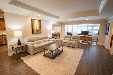 Living room featuring a coffered ceiling, crown molding, recessed lighting, bright  open .